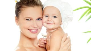 一个快乐的女人在白色背景下抱着一个快乐的孩子