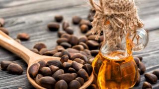 雪松坚果木勺的特写视图,雪松木油的罐