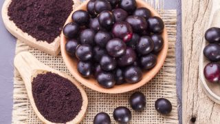 木制背景上的水果和巴西莓粉