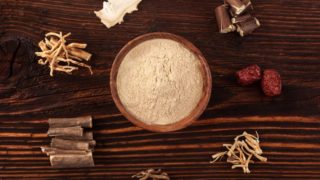 不同品种的适应草药围绕一碗草药粉