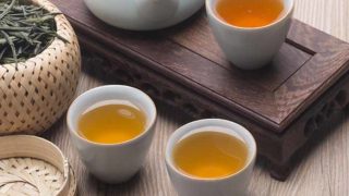 中国集茶壶的,并与一篮子绿茶和绿茶叶茶杯
