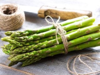 asparagus01 木桌上放着一束新鲜的绿色芦笋,绳子和刀