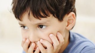 一个患有自闭症的小男孩的特写在白色背景上