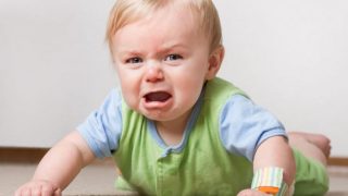 一个哭泣的婴儿趴在她的肚子上。