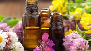 三个被五颜六色的花包围的精油瓶