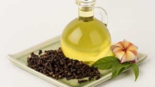 白碟上有丁香和花的精油瓶