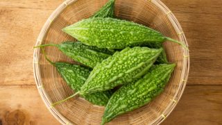 木桌上放着一篮苦瓜