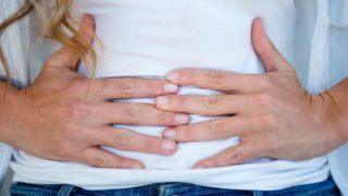 一名妇女双手紧握着肚子