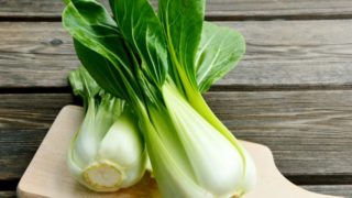 两个bok choy小花的特写镜头图象在一个木切板的