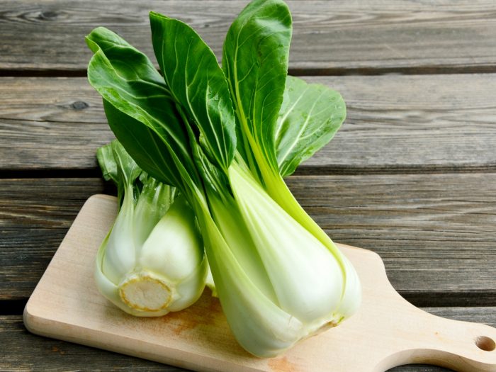 两个bok choy小花的特写镜头图象在一个木切板的