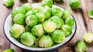 新鲜的绿色汤菜在陶瓷碗上一张木桌