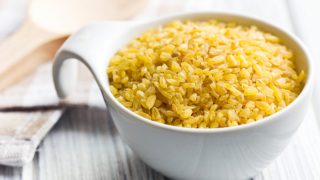 一杯碾碎干麦在一张木桌上