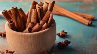 肉桂棒在碗里,八角在蓝色背景上