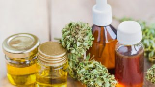 CBD油和麻油的瓶上一张木桌大麻叶旁