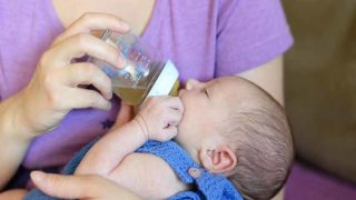 一个女人给她的婴儿奶瓶带