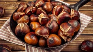 木台子上的厨房餐巾上放着一锅烤栗子