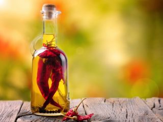 chilioil 这是一个辣椒油瓶的特写镜头,里面装满了整个辣椒和黑胡椒