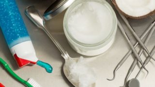 广口瓶,牙膏管,两把牙刷,椰子半部,以及各种牙科设备Flatlay图。