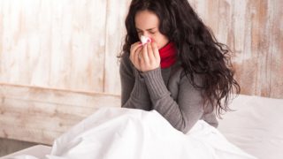一名病的女人吹她的鼻子。
