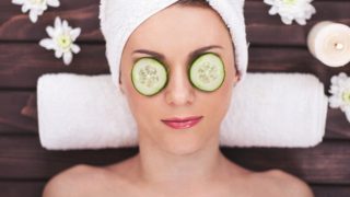 一个年轻的女人享受着spa,她的眼睛被黄瓜片覆盖着