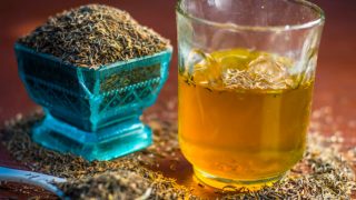 孜然水的玻璃和茴香籽一碗