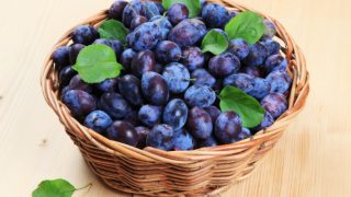 Damson李子特写镜头与叶子的在篮子