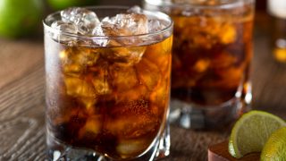 在岩石的两杯黑暗的酒特写镜头在岩石与切片石灰