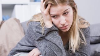 一个愁眉苦脸的女人用一只手托着头。