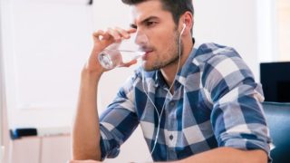 戴着耳机喝水的男人