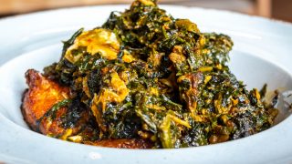 一盘白色背景的尼日利亚蔬菜Efo Riro汤