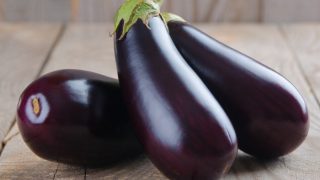 在一张木桌上安置的新鲜的茄子特写镜头视图