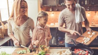 夫妇同时在家中厨房做饭daugher微笑