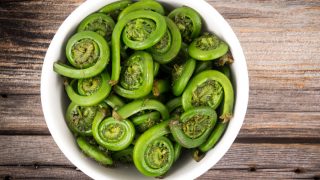 木质背景上的白色碗里的小提琴头