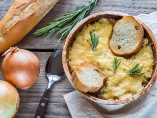 frenchonionsouptwo 木桌上放着一碗洋葱汤的特写