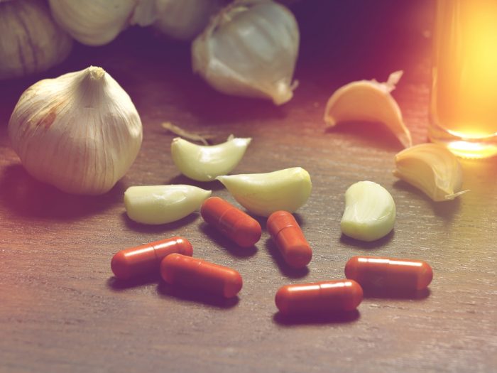 木头表面上的大蒜荚和药丸