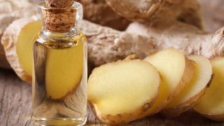 姜精油的切片和全姜在木桌上的容器