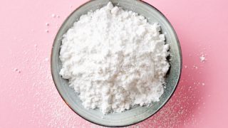 在一个碗的葡萄糖粉末在桃红色柜台