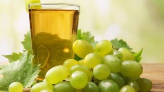 一杯葡萄汁放在绿葡萄旁边