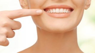 一个女人微笑着,并显示到相机她的牙齿