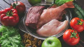 健康食品体重增加(生鸡,鱼,猪肉,西红柿,红辣椒,苹果,黄瓜,鸡蛋,菠菜,牛奶,杏等)上的木桌