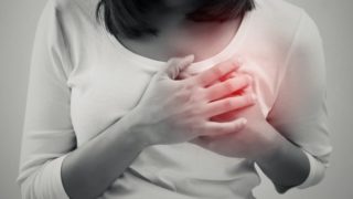 一个穿着白色t恤的女人双手放在胸前