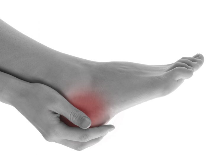 脚后跟疼痛处用红色高亮标记疼痛,并用一只手支撑