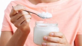 关闭了一个年轻女子的一瓶和匙椰子油