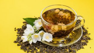 一杯茉莉花茶,黄色的背景上有茉莉花