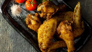 炸鸡翅,番茄和精细的喜马拉雅盐撒上香菜服务