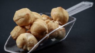 在深色背景充满库奎坚果透明勺子的特写