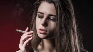 一个女孩一边抽烟一边哭