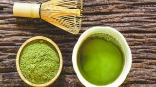 绿色液体在杯子里,绿色粉末在碗里,在木质表面上搅拌。