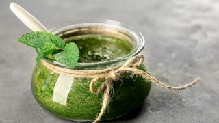 这是一个放在灰色平台上的装有薄荷酱的罐子的特写镜头