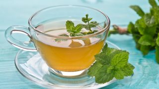 特写薄荷茶保持镜头顶上的蓝色平台